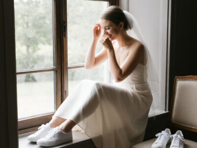 Невеста в кремовом платье и кедах у окна утром